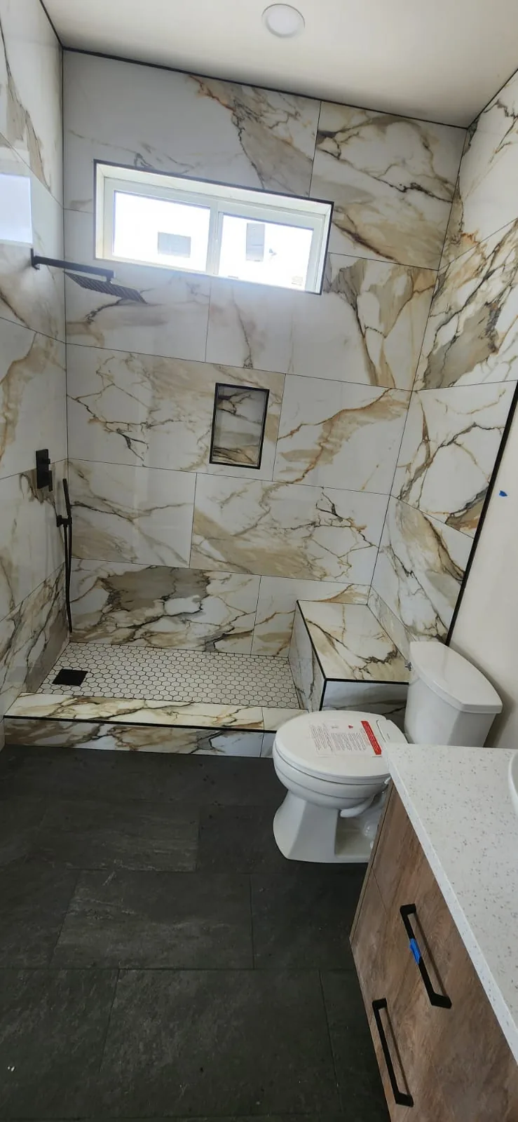 Professional water heater installation — clean mechanical room, new tank unit, copper pipe connections, tidy workmanship