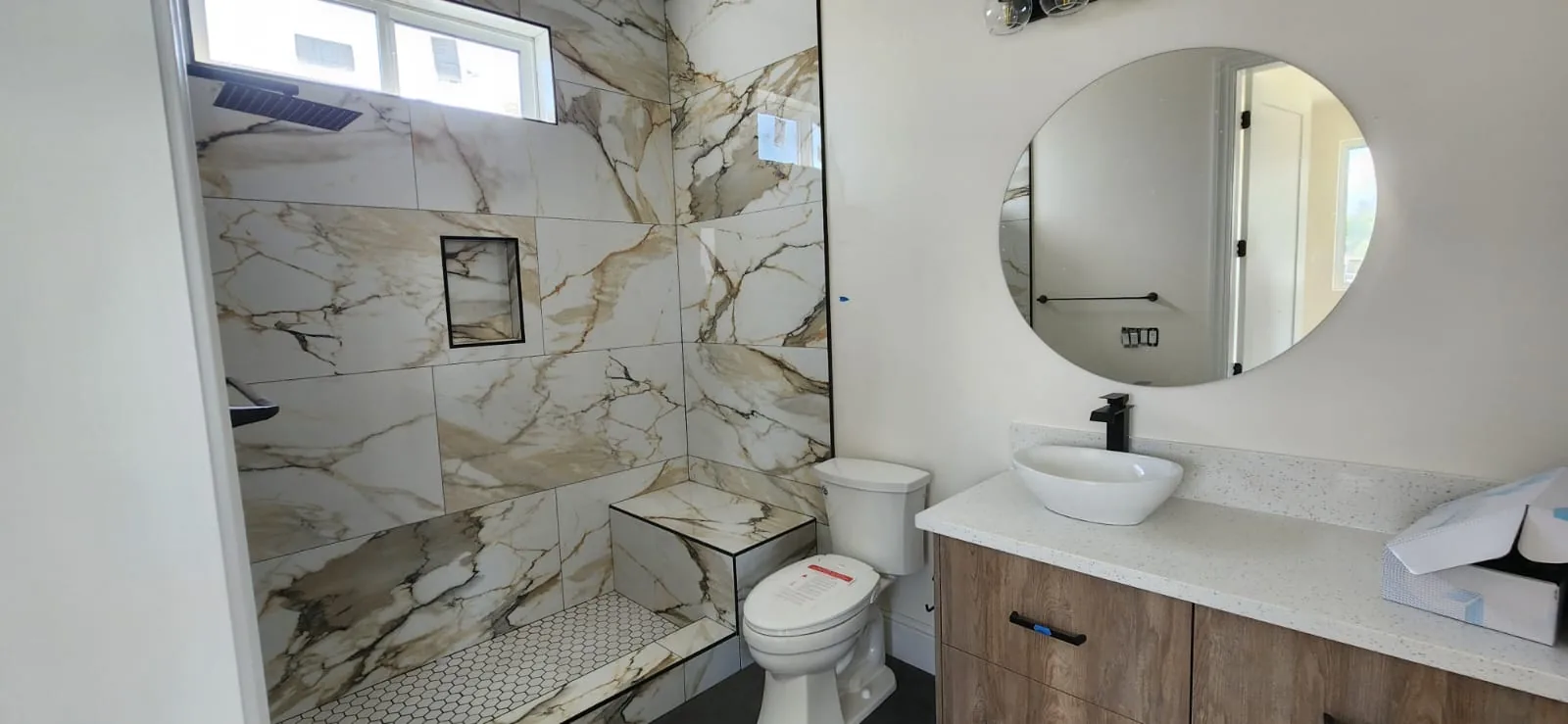 Bathtub installation — freestanding white tub, chrome faucet, tiled surround, clean bright bathroom space