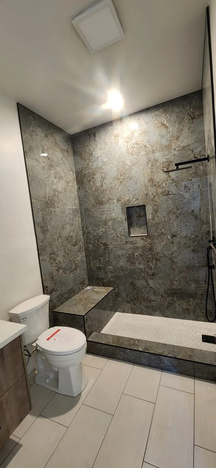 Toilet installation — white porcelain toilet, clean bathroom floor tile, new wax seal, complete finish installation